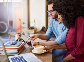 Diverse young couple working online together in a cafe