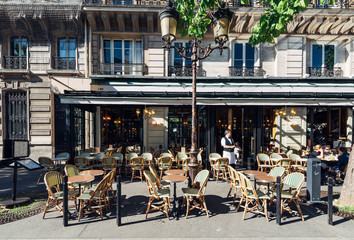 Typical view of the Parisian street with tables of brasserie (cafe) in Paris, France