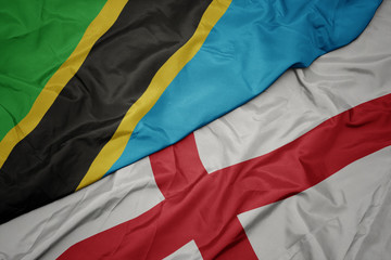 waving colorful flag of england and national flag of tanzania.