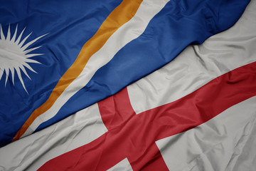 waving colorful flag of england and national flag of Marshall Islands .
