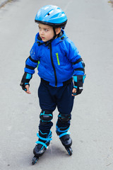 Cute little boy in a helmet on rollers