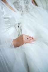 Foto op Plexiglas the bride holds in her hands a beautiful wedding dress © Дмитрий Ткачук