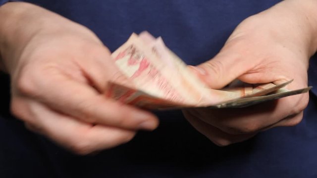 Man's hands counting Nepalese Rupee banknotes. National Currency of Nepal (NPR)