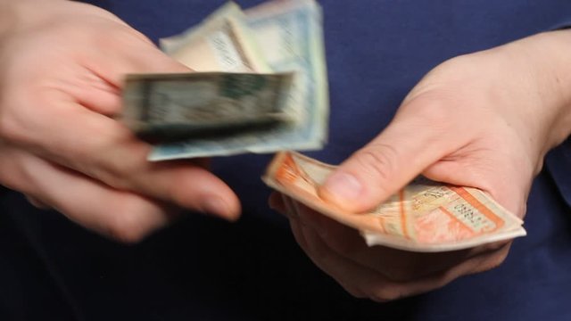 Man's hands counting Nepalese Rupee banknotes. National Currency of Nepal (NPR)