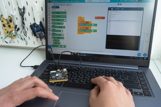 Minsk, Belarus. October, 2019. The BBC robot Micro Bit is connected to a computer. A teenager boy is programming it on Scratch and Python. Creative. Connected. Coding. Learning, teaching easy and fun.