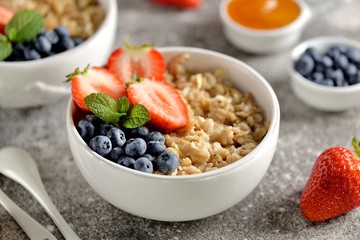Oatmeal porridge with organic blueberries, strawberries, honey and mint.