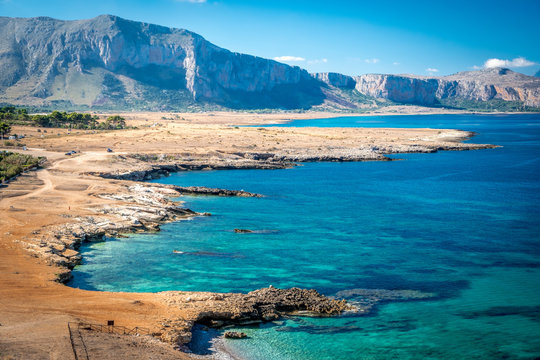 Azure Tyrrhenian sea picturesque bay, Monte Cofano mount and Bue Marino Beach view, Macari, San Vito Lo Capo region, Sicily, Italy. People are unrecognizable.