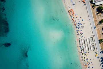Aerial view of San Vito Lo Capo,Sicily white sand beach. Sun loungers, umbrellas and the sea, view from a quadrocopter