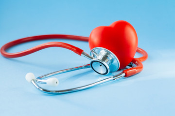 Stethoscope and red heart on blue background.