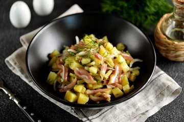 Smoked pork ears salad with boiled potatoes, pickles, onions, dill and olive oil.