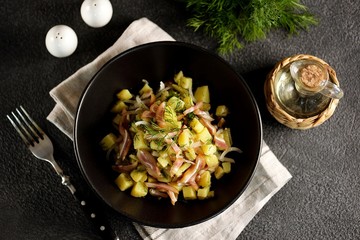 Smoked pork ears salad with boiled potatoes, pickles, onions, dill and olive oil.