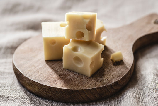 Swiss cheese cubes on a wooden board