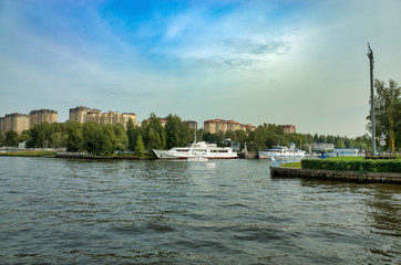 Obraz premium Moscow, Russia - September 8, 2018: Khimka River, Moscow Canal. Embankment Dolgoprudny. Residential buildings near the river, pier with boats