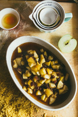 Photography series how to make an apples crumble , from the ingredients to the finish cake, rustic environment, apple pieces cut are cooked with sugar and water, then put in a baking dish