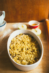 Photography series how to make an apples crumble , from the ingredients to the finish cake, rustic environment, pieces of shortcrust cover the apples melted and put in oven for 40 minutes at 180 degre