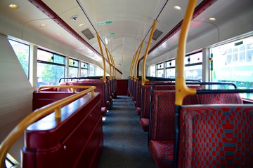 Empty seats on a double-decker red bus with no passengers in London, England