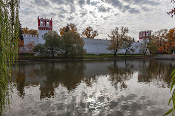 Fototapeta premium Walls and towers of the Novodevichy Convent, reflected in the water of the lake