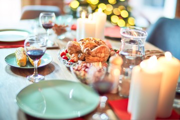 Setting of christmas table on festive holidays, full of traditional food with turky and delicious meals around the tree lights and decoration