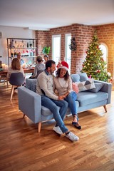 Obraz premium Family and friends dining at home celebrating christmas eve with traditional food and decoration, romantic senior couple talking together sitting on the sofa