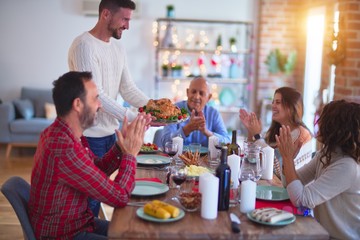 Beautiful family smiling happy and confident. Showing roasted turkey and applauding celebrating Christmas at home