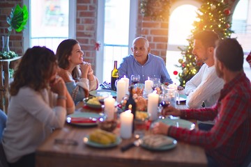 Beautiful family smiling happy and confident. Eating roasted turkey celebrating Christmas at home