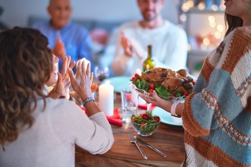 Beautiful family smiling happy and confident. Showing roasted turkey and applauding celebrating Thanksgiving Day at home