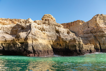 Seascape with eroded sandstone cliffs on the Algarve, off the southern Portuguese coast,under clear clue sky