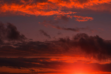 Fiery orange sunset  colorful and speckled  clouds.
