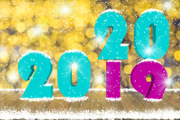 2020 Text on wood table top with snow and decorative light bokeh background