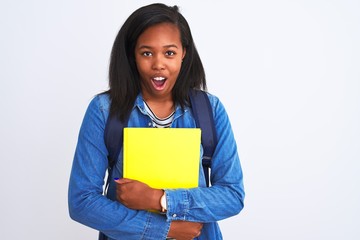 Fototapeta premium Young african american student woman wearing backpack and book over isolated background scared in shock with a surprise face, afraid and excited with fear expression