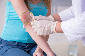 Young arm injured woman visiting young doctor traumatologist