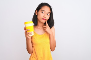 Young chinese woman drinking take away glass of coffee over isolated white background serious face thinking about question, very confused idea
