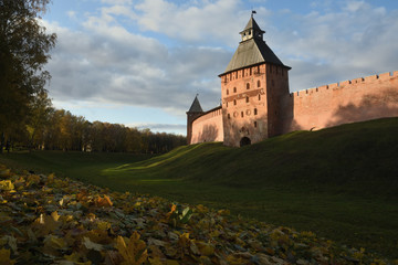 Autumn park with fallen leaves in the foreground and ancient towers. Veliky Novgorod. Novgorod Kremlin