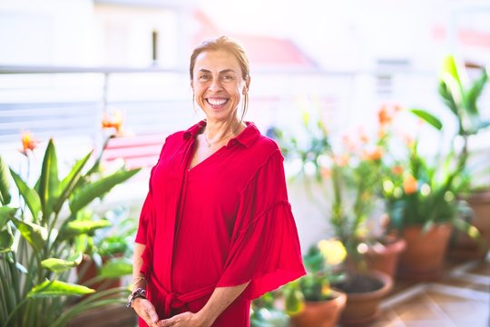 Middle age beautiful woman smiling happy and confident standing with a smile on face at terrace