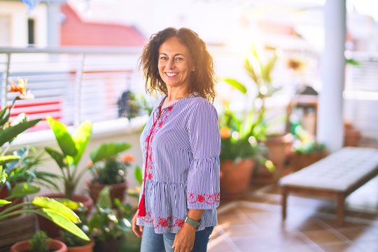 Middle age beautiful woman smiling happy and confident standing with a smile on face at terrace
