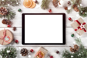 Creative layout frame made of Christmas tree branches, pine cones and  tablet pc on white wooden  background. Xmas and New Year theme. Flat lay, top view, space for text