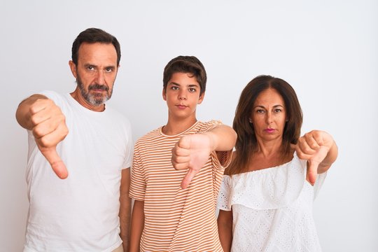 Family Of Three, Mother, Father And Son Standing Over White Isolated Background Looking Unhappy And Angry Showing Rejection And Negative With Thumbs Down Gesture. Bad Expression.