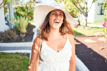 Young beautiful woman on white houses village walking on the streets on a sunny day of summer