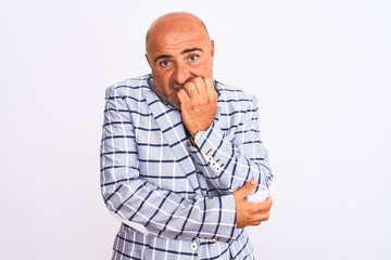 Obraz premium Middle age businessman wearing suit standing over isolated white background looking stressed and nervous with hands on mouth biting nails. Anxiety problem.