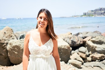 Fototapeta na wymiar Beautiful young woman walking on beach promenade enjoying ocean view smiling happy on summer vacation