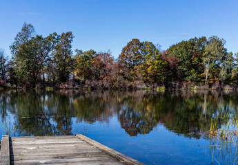 Small dock at Lake Erie with fall and autumn colored trees in the back ground 