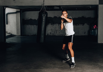 Young muscular sports guy practicing boxing