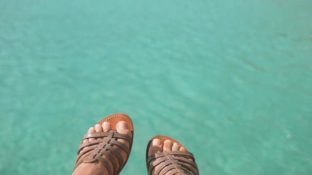 Woman's feet above blue water