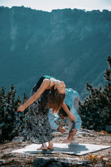 Portrait of a young dancing friends on cliff over blue sky
