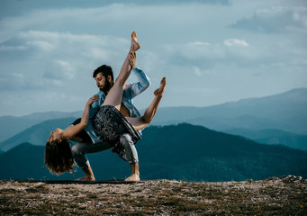 Two modern dancers practicing dancing on the mountain cliff