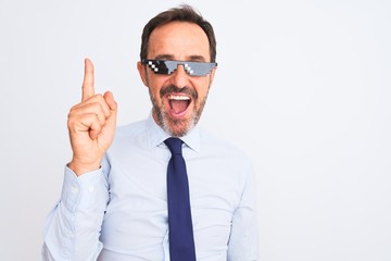 Middle age businessman wearing thug life sunglasses over isolated white background pointing finger up with successful idea. Exited and happy. Number one.