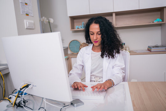 Portrait Of A Nurse Working On Her Computer In The Lobby.