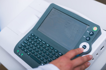 Close up photo on a EKG machine while an older man gets his heart checked.