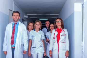 Group of medical staff, team doctors and nurses posing in the hallway of a hospital, clinic.