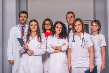 Group of medical staff, team doctors and nurses posing in the hallway of a hospital, clinic.